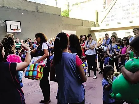 Chicos y familias en el patio durante un acto del colegio