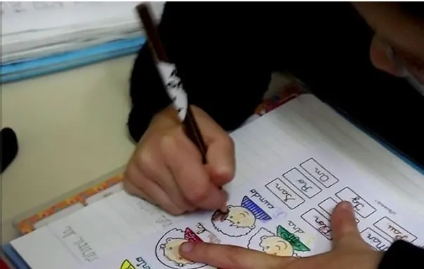Manos de un alumno completando la actividad en el cuaderno